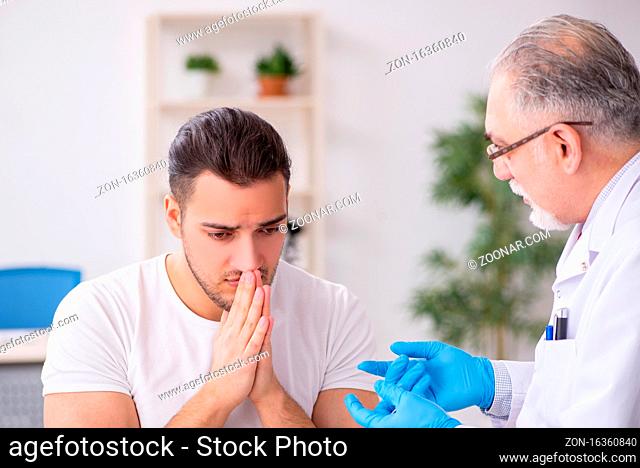 Young man visiting old doctor dermatologist