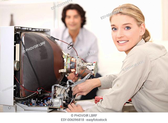 Woman repairing television set
