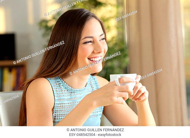 Happy lady drinks coffee looking away