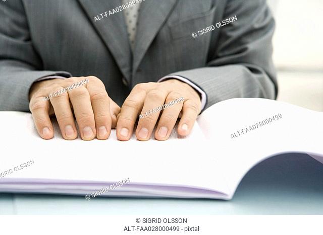Professional man reading Braille, cropped view of hands