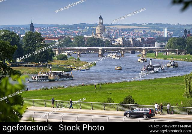 10 July 2021, Saxony, Dresden: Steamers cruise the Elbe on a round trip between Terrassenufer and Pillnitz Palace. Seven historic paddle steamers of the...