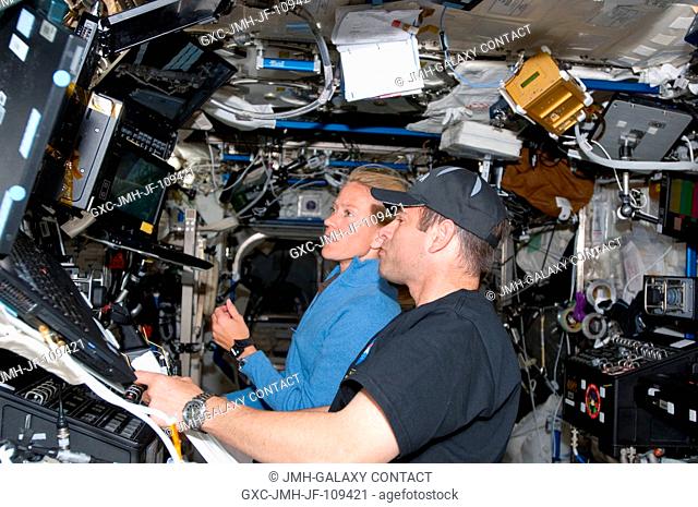 Astronauts Greg Chamitoff, Expedition 17 flight engineer, and Karen Nyberg, STS-124 mission specialist, use the controls of the International Space Station's...