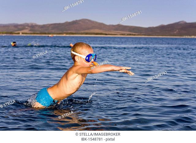 Boy, 5 years, wearing diving goggles and snorkel, jumping