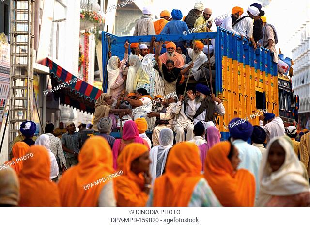 Sikh devotees travelling on truck to attained 300th year celebrations of Consecration of perpetual Guru of Sikh Guru-Granth at Sachkhand Saheb Gurudwara ;...