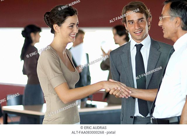 Colleagues shaking hands in office