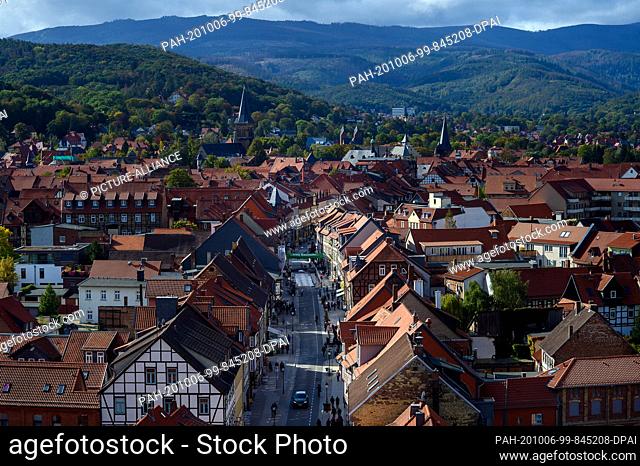 06 October 2020, Saxony-Anhalt, Wernigerode: The light-coloured facades of the half-timbered houses and the red roofs of the town stand out against the fading...