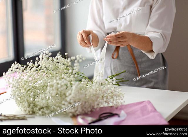 woman or floral artist making flower bunch