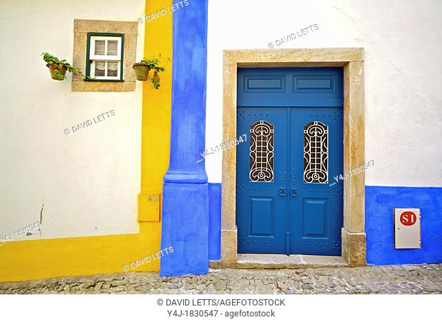 Blue Wood Ornate Door against a Whitewashed Plaster Wall