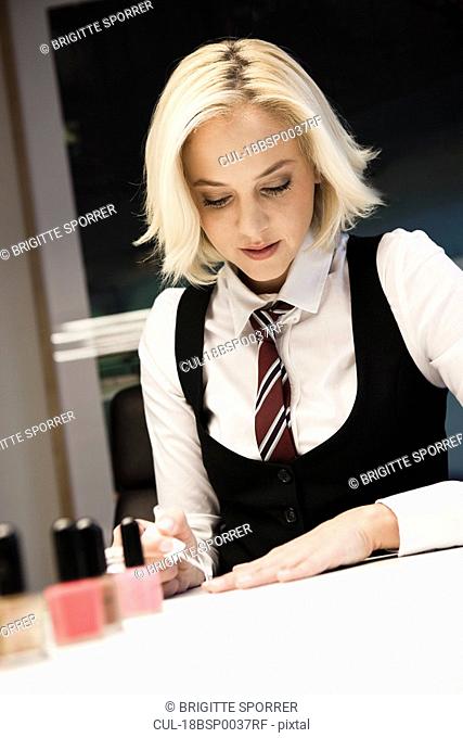 Blond woman polishing nails