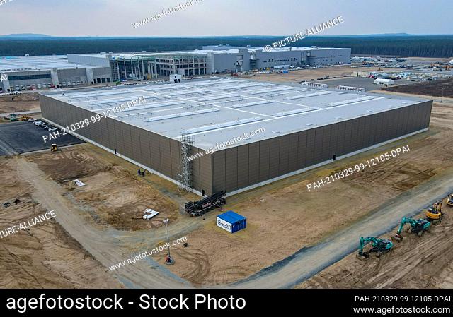 26 March 2021, Brandenburg, Grünheide: The construction site of the Tesla Gigafactory with the production hall (back) and the hall for painting (front