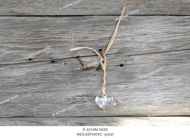 Germany, Ammersee, Plastic heart hanging against wood