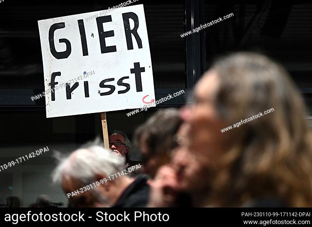10 January 2023, North Rhine-Westphalia, Erkelenz: A demonstrator holds up a sign reading ""Greed eats"" during an information event on the clearance of the...