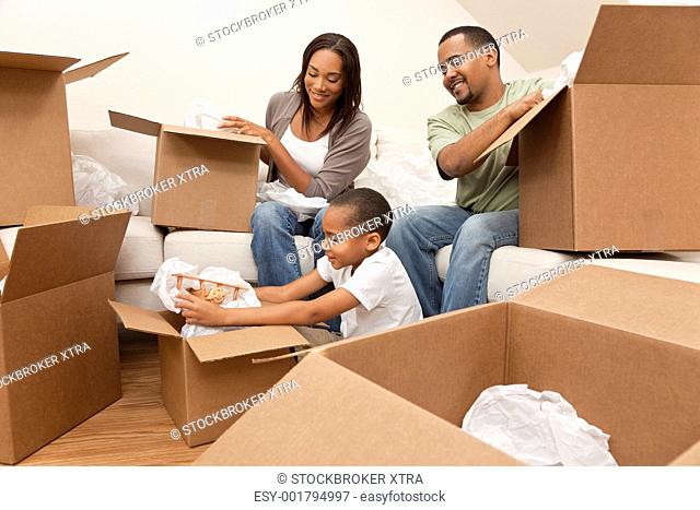 African American family, parents and son, unpacking boxes and moving into a new home, The adults are unpacking crockery and houseware