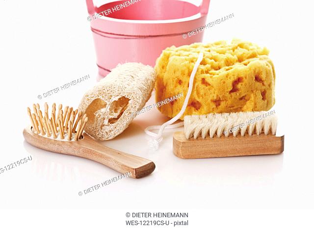 Sponges and brushes with basket on white background