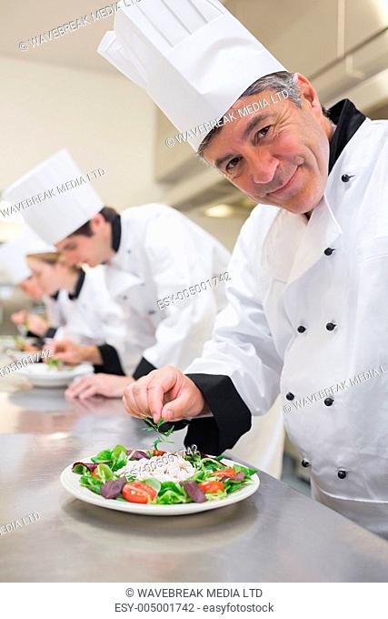 Cheerful Chefs preparing their salads in the kitchen