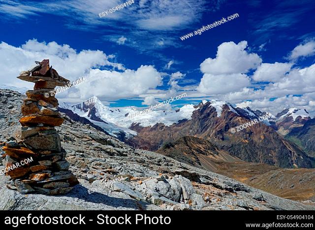 picturesque mountain landscape in the Cordillera Blanca in the Andes of Peru with a stone cairn in the foreground