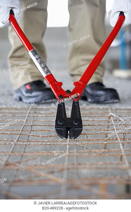 Worker cutting wire in plank mould with pliers. Housing construction, apartments. San Sebastian, Gipuzkoa, Euskadi. Spain