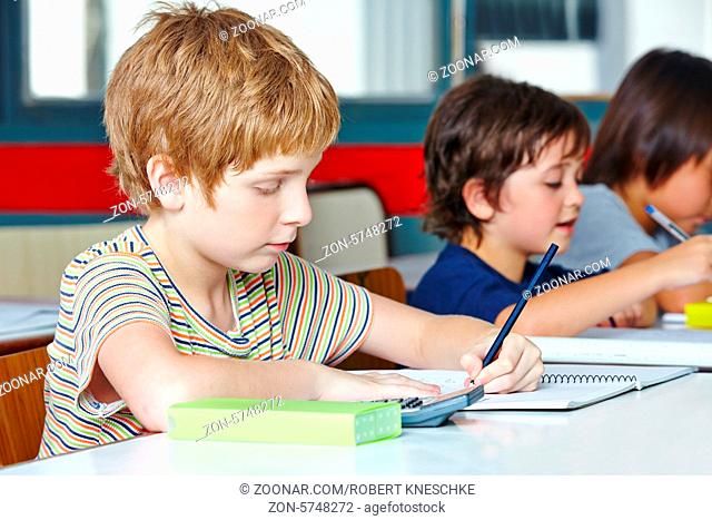 Kind als Linkshänder schreibt in der Schule mit Bleistift