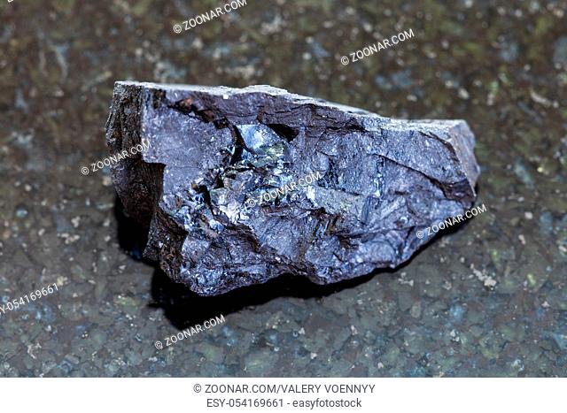 macro shooting of natural mineral rock specimen - raw Anthracite coal on dark granite background