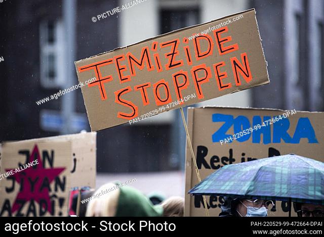 29 May 2022, Berlin: During a demonstration against violence against women, a participant holds a placard with the inscription ""Stop femicides""