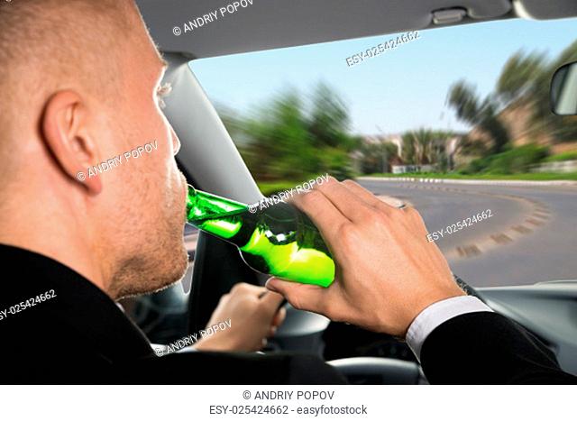 Close-up Of A Businessman Drinking Beer While Driving Car