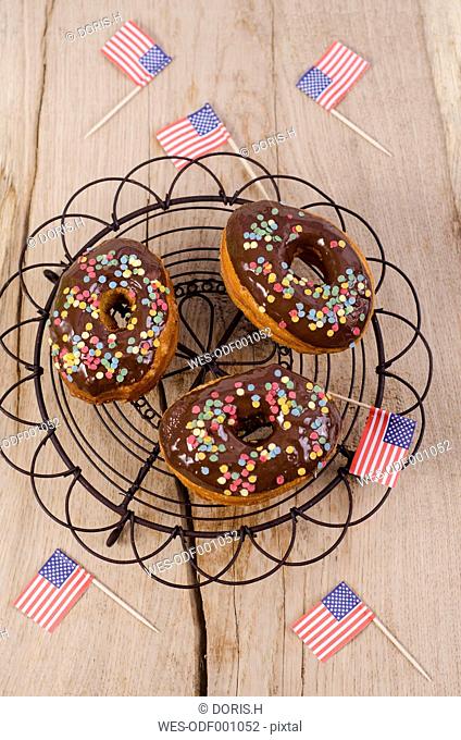 Three American cronuts with chocolate icing and sugar confetti