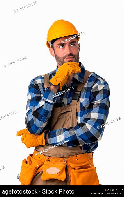 Portrait of contractor worker in coveralls and hardhat holding chin isolated on white background