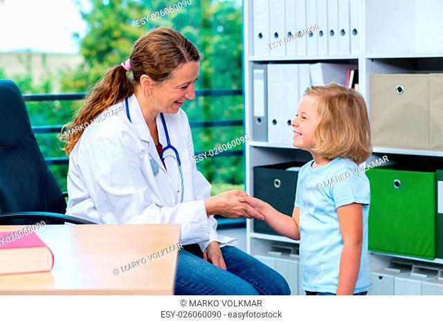 female pediatrician in white lab coat greeting little patient