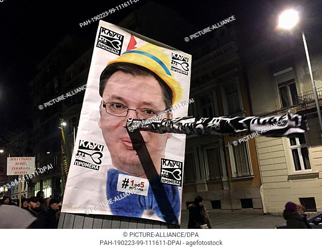 23 February 2019, Serbia, Belgrad: Protesters hold a poster of president Alexander Vucic with a long Pinocchio nose during a protest against President Vucic's...