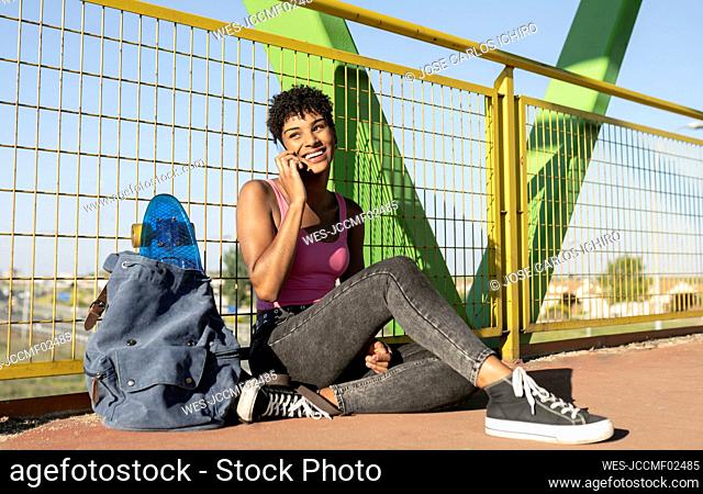 Young woman looking away while talking on smart phone