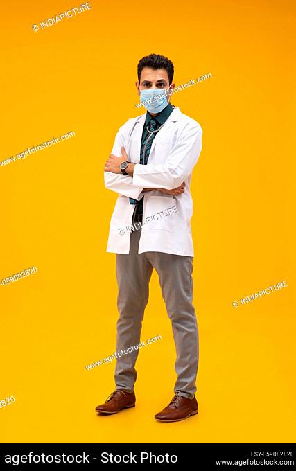 PORTRAIT OF A DOCTOR WEARING FACE MASK AND LOOKING AT CAMERA