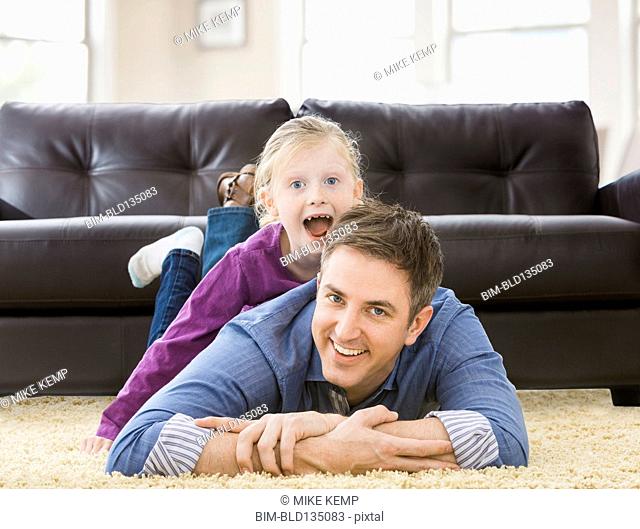 Caucasian father and daughter playing in living room