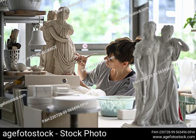 25 July 2023, Berlin: At the Königliche Porzellan-Manufaktur Berlin, manufactorer Anja Sonn removes so-called casting seams from the princess group
