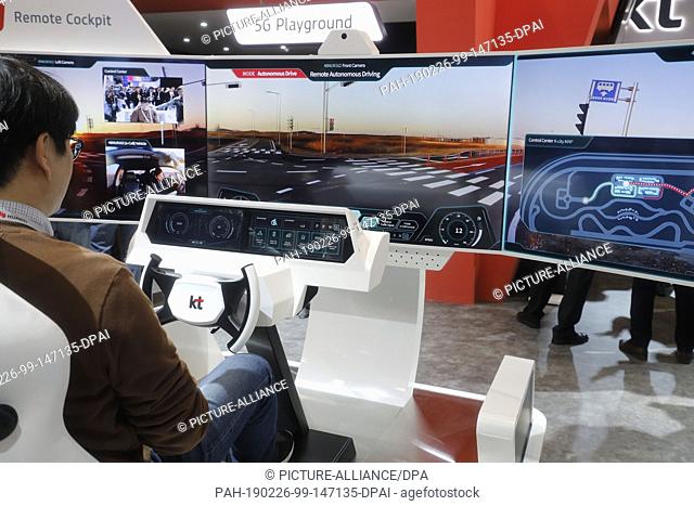 26 February 2019, Spain, Barcelona: Visitors try out a remote cockpit at Korea Telekom's booth at the Mobile World Congress 2019 in Barcelona