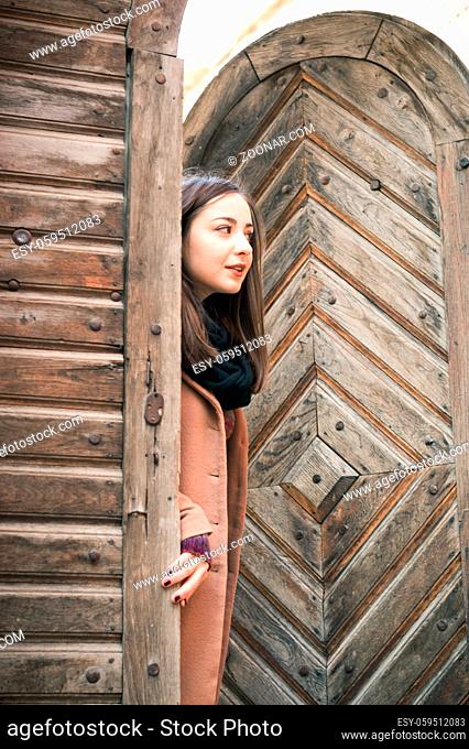 beautiful girl near old wooden gate in the city