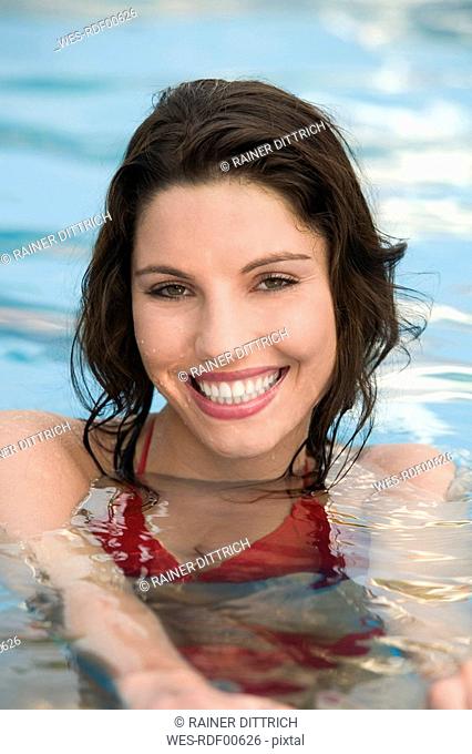 Asia, Thailand, Young woman in pool, smiling, portrait