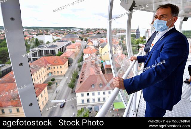 11 July 2020, Thuringia, Weimar: Peter Kleine (Parteilos), Lord Mayor of Weimar, looks down on the city from the mobile viewing platform ""City Skyliner""