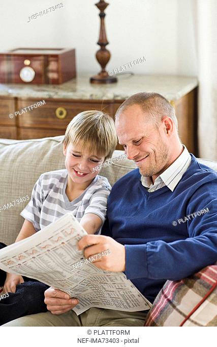 Father and son reading the newspaper, Sweden