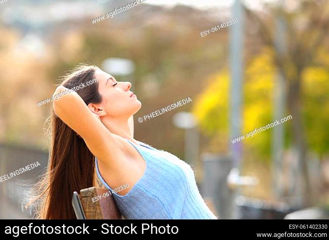 Relaxed teen resting sitting on bench in a park
