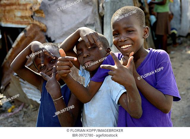 Three boys posing with wild gestures, Camp Icare for earthquake refugees, Fort National, Port-au-Prince, Haiti