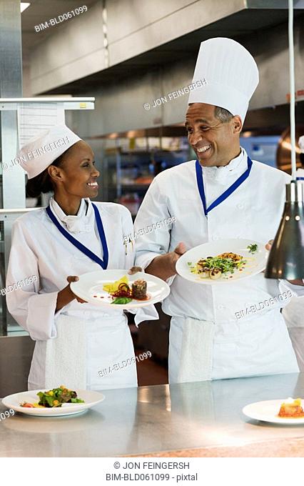 African chefs holding plates of food
