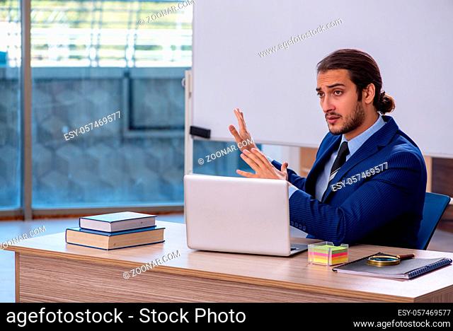 Young teacher in suit in the classroom