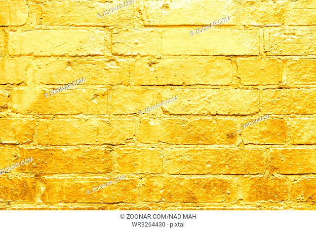 brick wall painted in gold - golden graffiti background