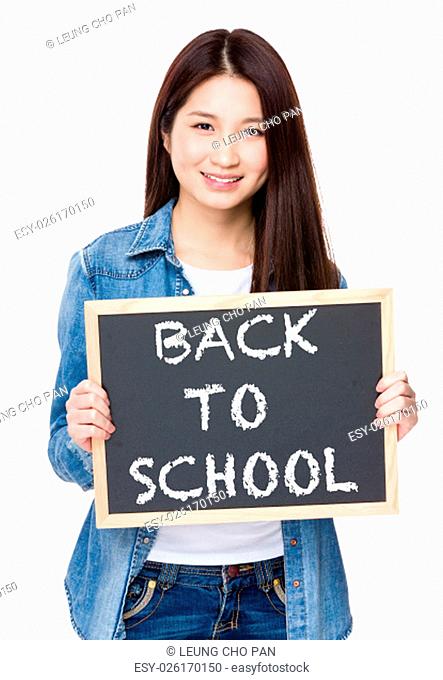 Young woman hold with chalkboard showing phrase of back to school