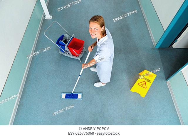 High Angle View Of Janitor With Mop Cleaning Floor Of Corridor Pass