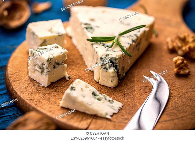 Slices of danish blue cheese on wooden cutting board