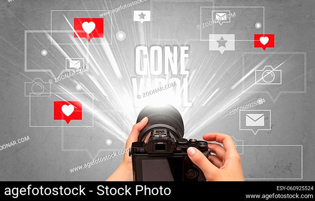 Close-up of a hand taking photos with GONE VIRAL inscription, social media concept