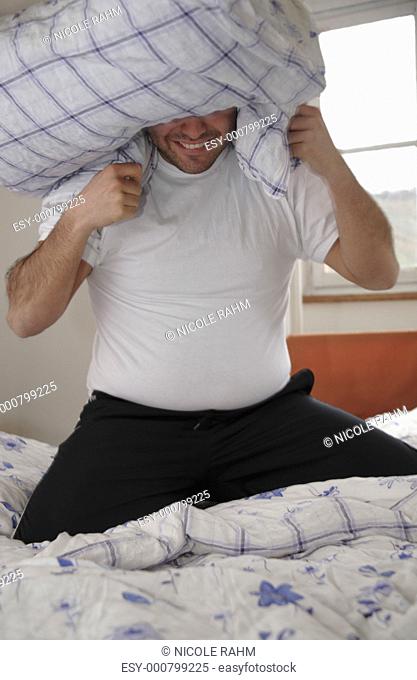 Young man in a pillow fight