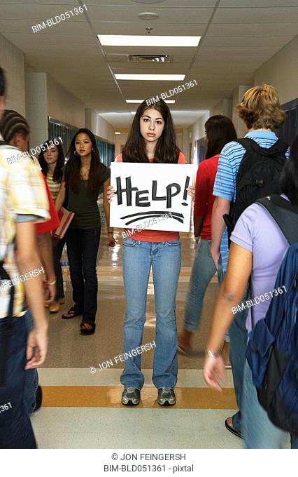 Female teenaged student holding Help sign