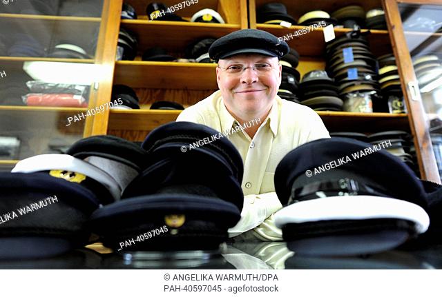 Cap maker Lars Kuentzel stands behind the counter in Hamburg, Germany, 15 March 2013. Since 1892 the cap shop Eisenberg produces and sells caps called Altona